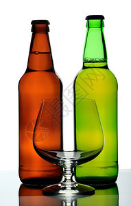 棕色的两瓶啤酒和玻璃白底隔离在色背景上透明液体图片