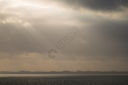 风景优美沙丘海洋和阳光雾乌云的风景太阳背景图片