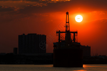 天空背景日落船只的轮光图片底日落工业的晚上图片