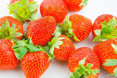 新的白色红背景新鲜草莓图片