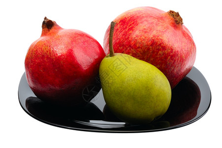 白色的自然颗粒石榴和梨子放在一个孤立的黑色白板上健康图片