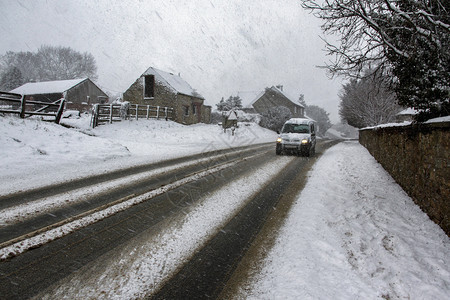 在英格兰东北部约克郡乡下冬季在大雪中驾着车过冬气候淋浴农村图片