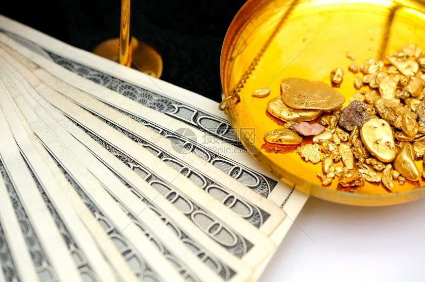 钱RawGoldandMoney黄金和货币块在一个平衡比额表中以五百一张钞票显示两者的价值有两个都图片