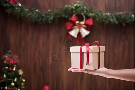 周年纪念日带圣诞快乐和新年背景的手持礼物盒和新年快乐丝带盒子图片
