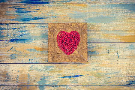 红心形状从金木框上的线珠和彩色木背景的红心形情人节象征珠子图片