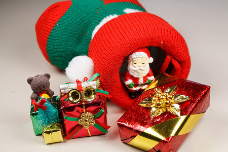 红色的绒球为了圣诞靴子老人雕像和礼物作为圣诞节的装饰品图片