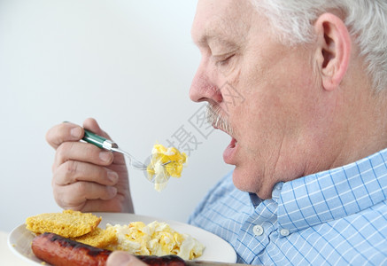 老男人吃炒鸡蛋香肠和玉米面包一顿饭爽朗手图片