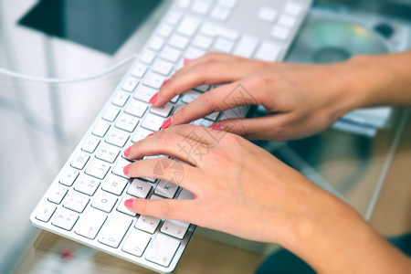 有创造力的沟通妇女打字在她的笔记本电脑上办公室图片