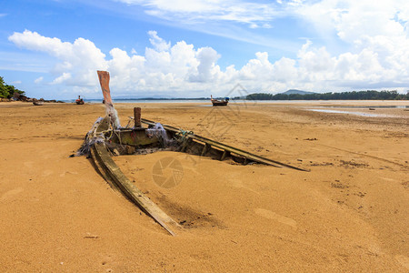破坏泰国普吉奈阳海滩沙土中埋藏的老船蓝色岩石图片
