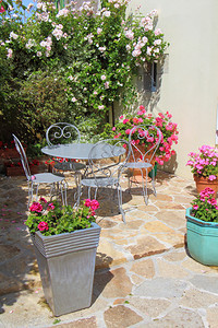 开花的椅子朵露台有灰色花园家具和春天一些带环的花盆锅图片