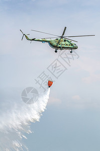 行动运送水的绿色消防直升机灭火扑灾难桶图片