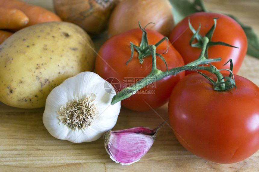 一些胡萝卜土豆洋葱西红柿大蒜和菜烹饪季节有机的图片
