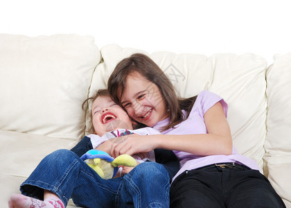 女团结一个孩在沙发上和她妹玩耍婴儿图片