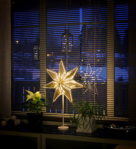 屋圣诞节窗户紧靠边的圣诞明星灯冬季下午蓝色时刻装饰图片