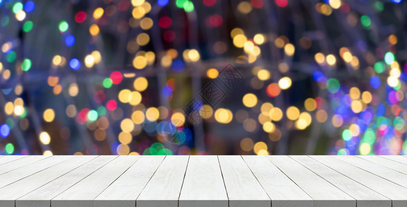 在圣诞节光线上顶的白木桌用于调制您产品时的模糊背景绿色桌子图片