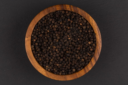 黑石本底木碗中的黑胡椒舀食物味道图片