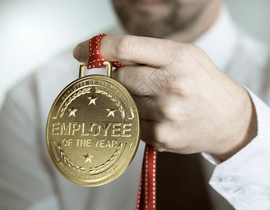 男人出类拔萃持有金奖章的雇员与一年奖励或动机概念承认国际年的雇员之间鼓励或激概念工人图片