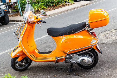 停在街边的明亮橙色摩托车速度运输小型摩托车图片