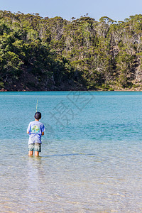 海岸新的澳大利亚南威尔士州Pampbula河口海边钓鱼男孩沿图片