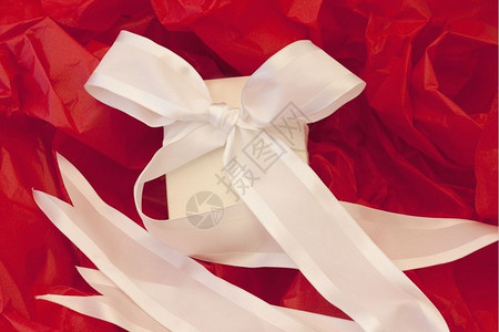 粉丝丝带喜庆的周年纪念日粉丝优雅包着白盒和丝带与红纸相对优雅的背景