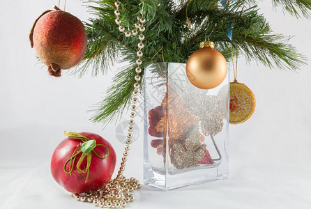 庆典白色的圣诞树枝和花瓶中的装饰包括人工石榴和苹果以及假期图片