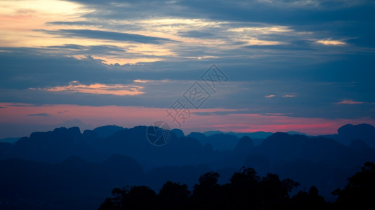 多云的日落时山剪影云景空气图片