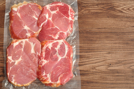 包装好的健康木制背景上展示的真空包装肉美食图片