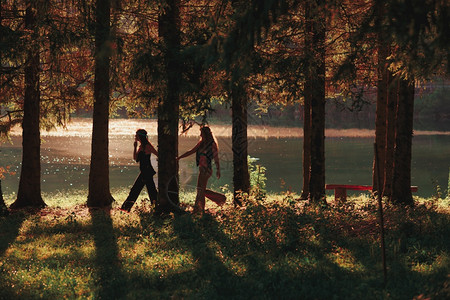 嬉皮妇女对齐在森林中携手并肩行走微笑放松自然图片