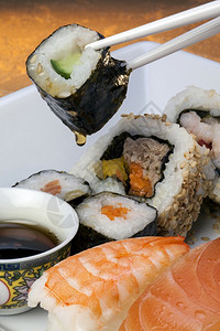 食物艾伦筷子寿司是一种日本菜盘由小球或一卷醋味冷饭和蔬菜鸡蛋或生海鲜的胡萝卜组成图片