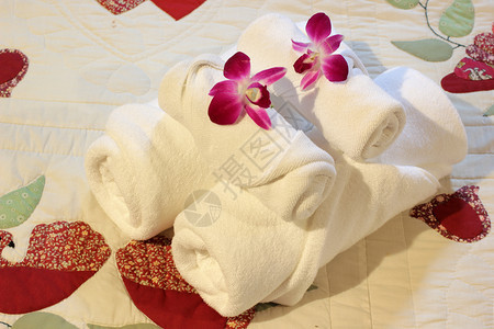 酒店浴室白巾卷起并堆在床上卫生图片