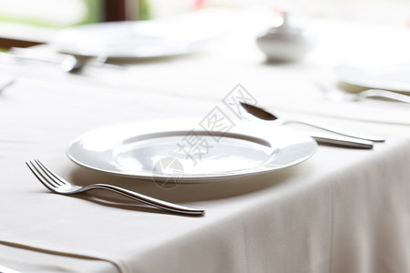 桌子装饰上带刀叉的白盘子带刀叉的白盘子出去食物图片