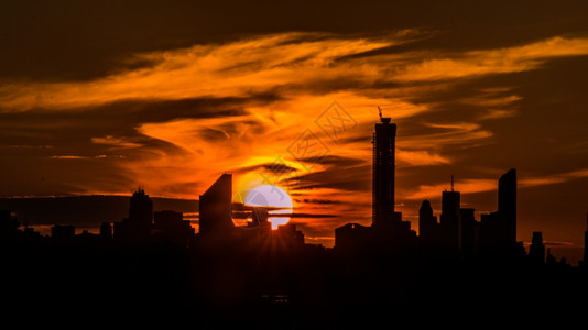 射线晚上自然在纽约的刮天机身后落下巨型美丽的太阳背景图片