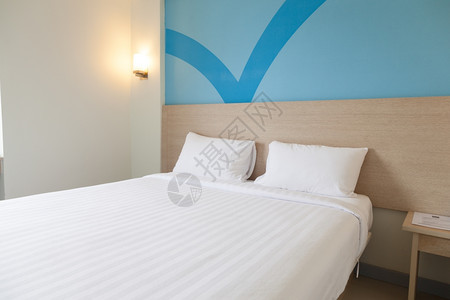 床铺枕头和毯子以及一个带蓝灯的房间奢华一种蓝色的图片