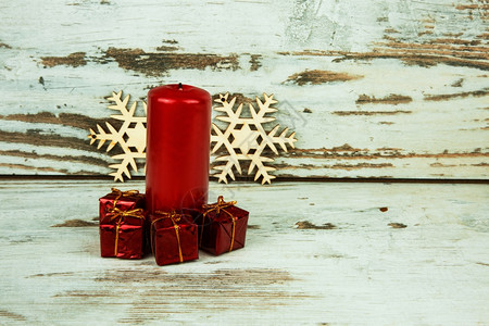 红纸蜡烛和旧木本底背景的2个装饰木雪花上4件小装饰礼品红色蜡烛和2个装饰木雪花目的庆典图片