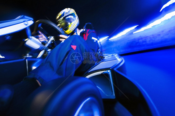 移位器GoCart赛车驾驶员在室内电路上登顶蓝色的黑暗图片