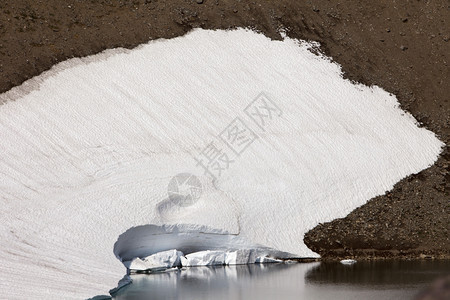 冰冷一座小田正在融化为MtRainier公园饮用水湖喝雪图片