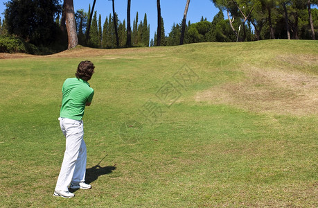 课程白色的播放器高尔夫玩家在球洞附近绿色地踢球图片