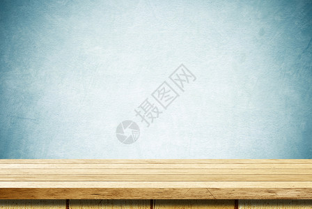 优质的空房间蓝色水泥墙背景上的空木制桌用于产品显示时的蒙戴图片