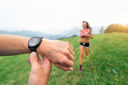 尽管运动训练教在自然运动的女孩时握住手表卡路里种族图片