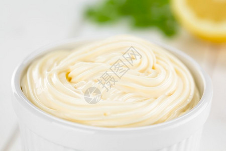 漩涡蛋黄酱在白色碗里柠檬和面在后的选择焦点中聚在图像的美乃滋间白色的图片