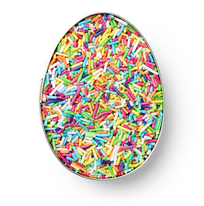 五彩缤纷白色背景的彩糖果以鸡蛋形式喷洒在切割机上绿色富劳卡图片