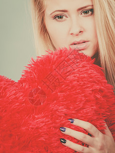 失望浪漫的伤害分手离婚坏关系概念萨德压抑的女士拿着大红发毛绒枕头在心脏形状她需要爱悲伤的女士抱着红枕头在心脏形状图片