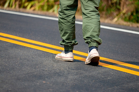 穿着运动鞋的男子在街上走着黄线积极的脚丫子户外图片