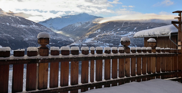 高山上美丽的冬季风景从一个有栅栏的雪覆盖Ans木梯子上登起降雪寒冷的下图片