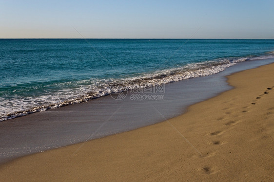 海景滩潮水在金沙上滚落阳光图片