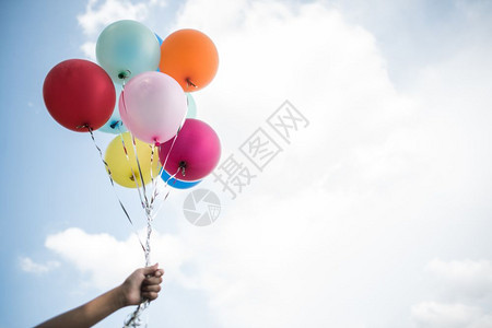 天空年轻女孩手持彩色气球保美丽的图片