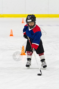 玩在冰球练习中男孩跟冰球滑溜曲棍加拿大图片