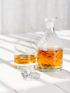 一种瓶子照片来自玻璃窗边桌子上的威士忌脱甘茶和石头玻璃酒图片
