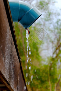 雨水从屋顶下沟中涌出垂直的建造花床图片