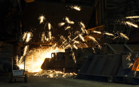 巨大的钻井在工业熔炉中制造一个灌满洞火花到处飞来去钻头熔化热的图片